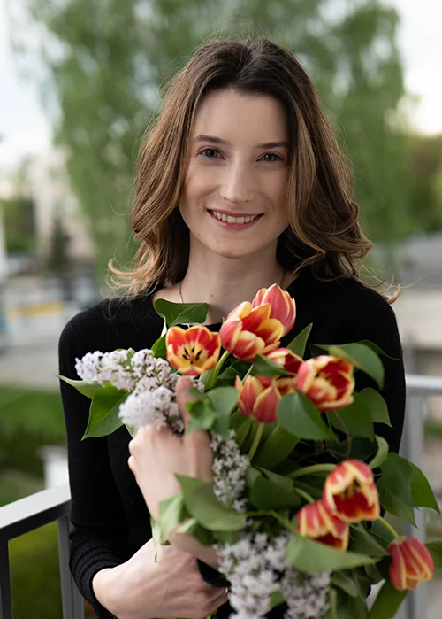 Kamila Boberek z kwiatami na świeżym powietrzu.